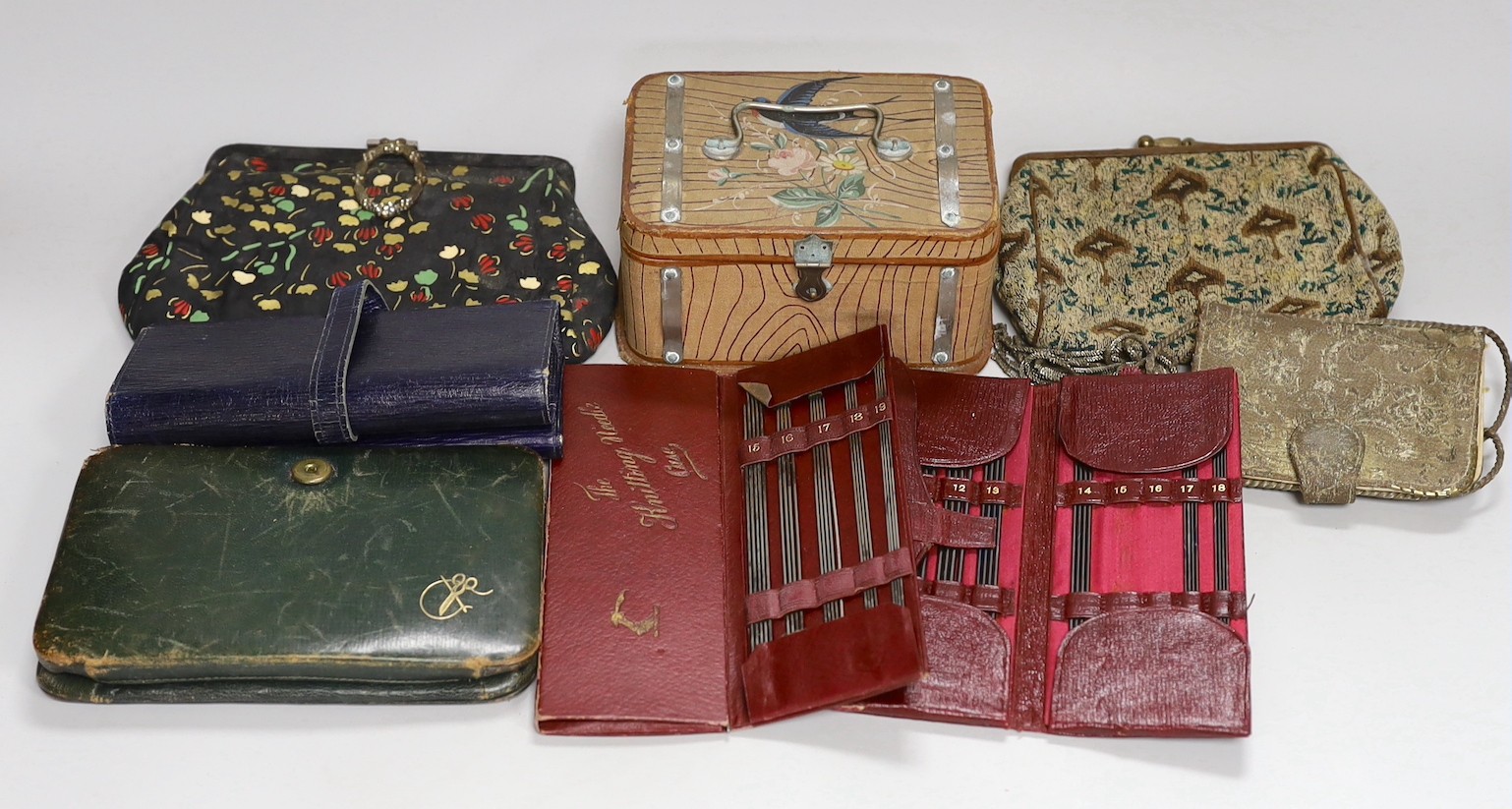 A suitcase containing a collection of late 19th century leather sewing bags and containers, wooden darning mushrooms, etc